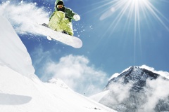 Snowboarder at jump inhigh mountains